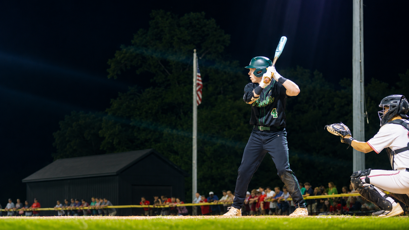 Baseball batter in stance under stadium lights at night